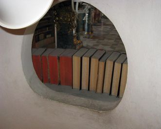 Eingebautes Loch zur Beleuchtung der Treppe hinter einem der Bücherregale